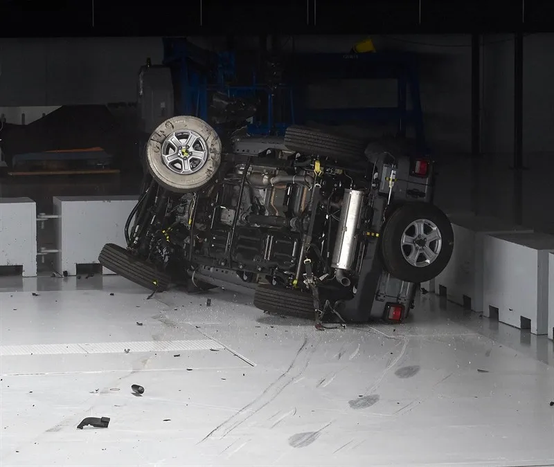 The 2019 Jeep Wrangler lying on its side after the small overlap test, underside toward the camera.